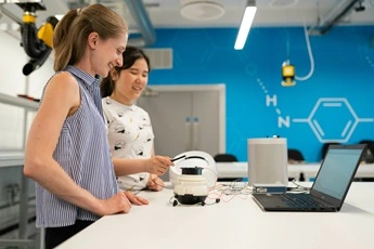 Female colleagues happily working on a project